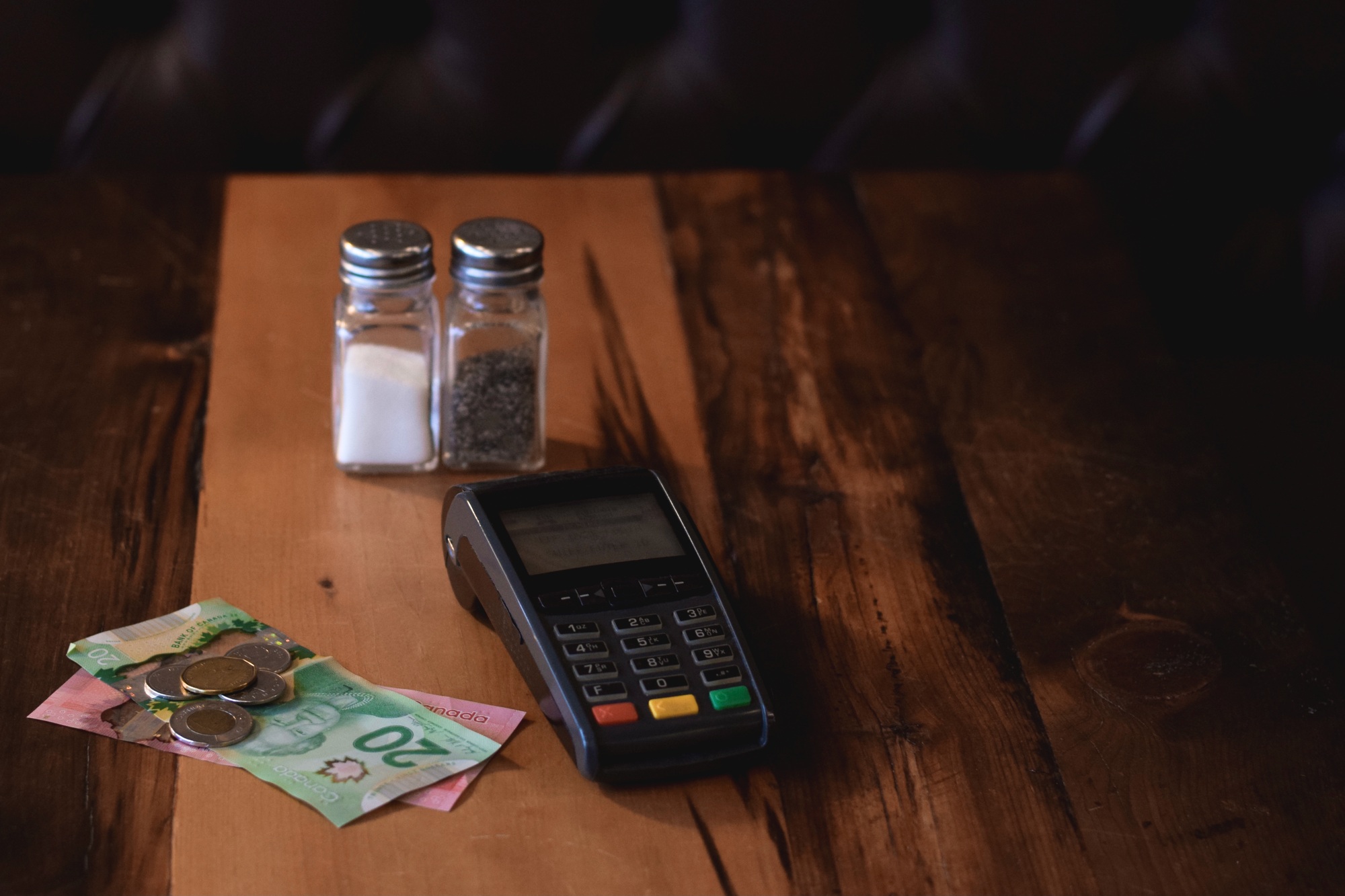 Cash money or tip and payment terminal on a restaurant table